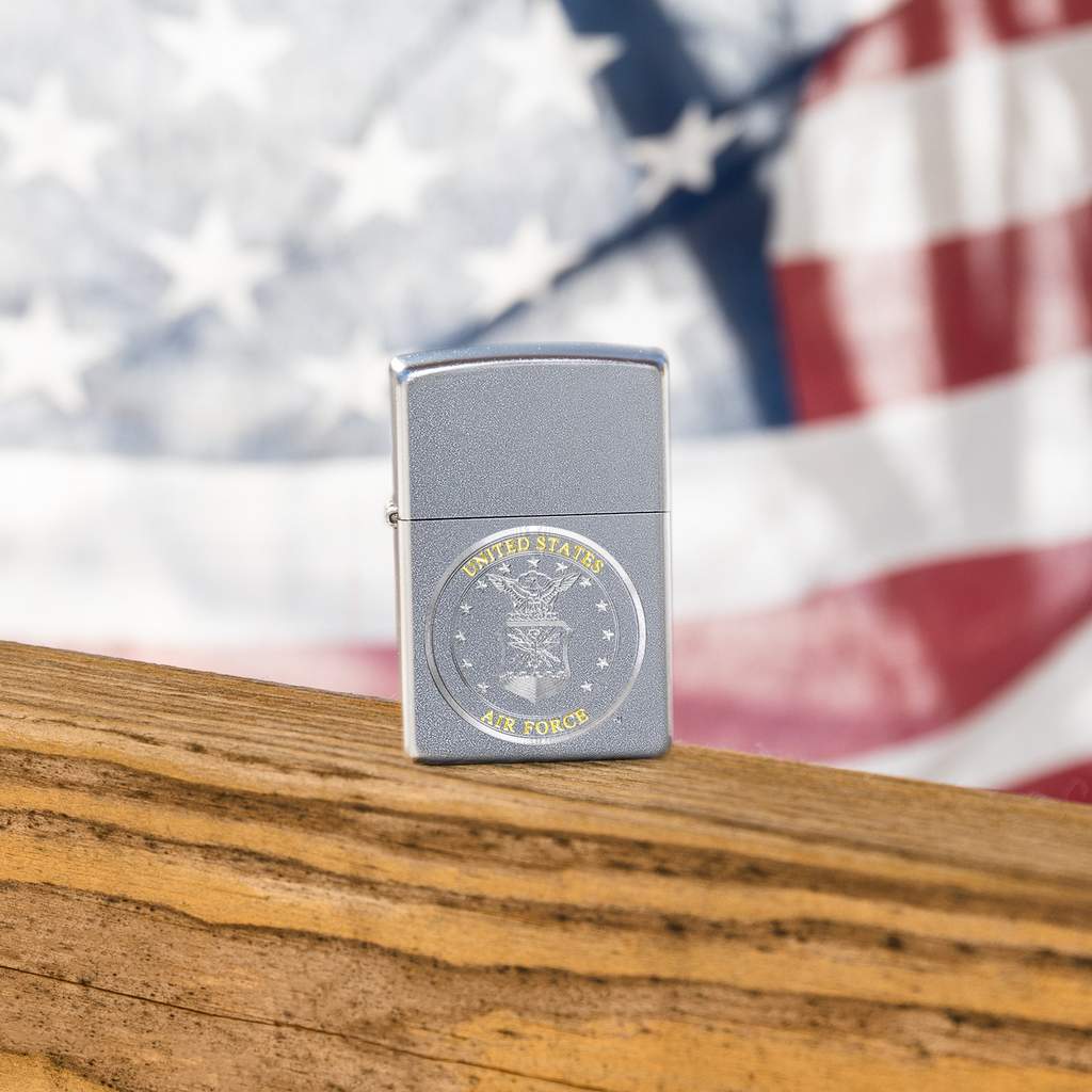 Lifestyle image of U.S. Air Force Crest Windproof Lighter with the American Flag in the background